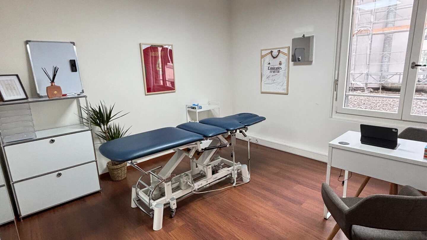 Cabine de physiothérapie au Lab : table de traitement, meuble blanc et maillots encadrés au mur