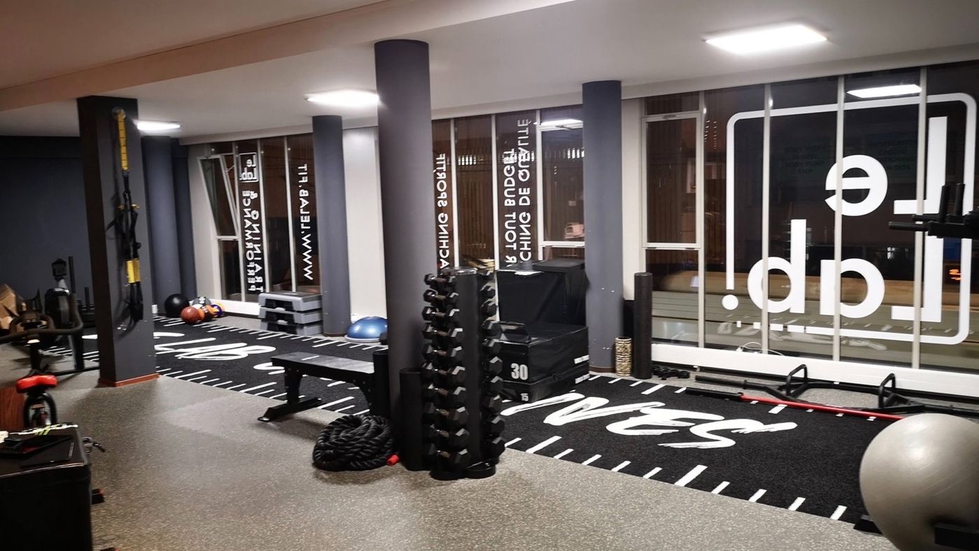 Espace d'entraînement du Lab avec bancs, haltères et grandes vitrines